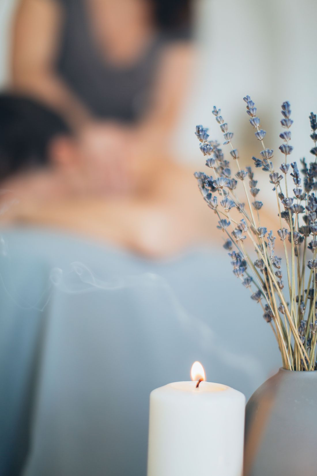Ambiance de l'institut : bougie, lavande et massage en arrière-plan
