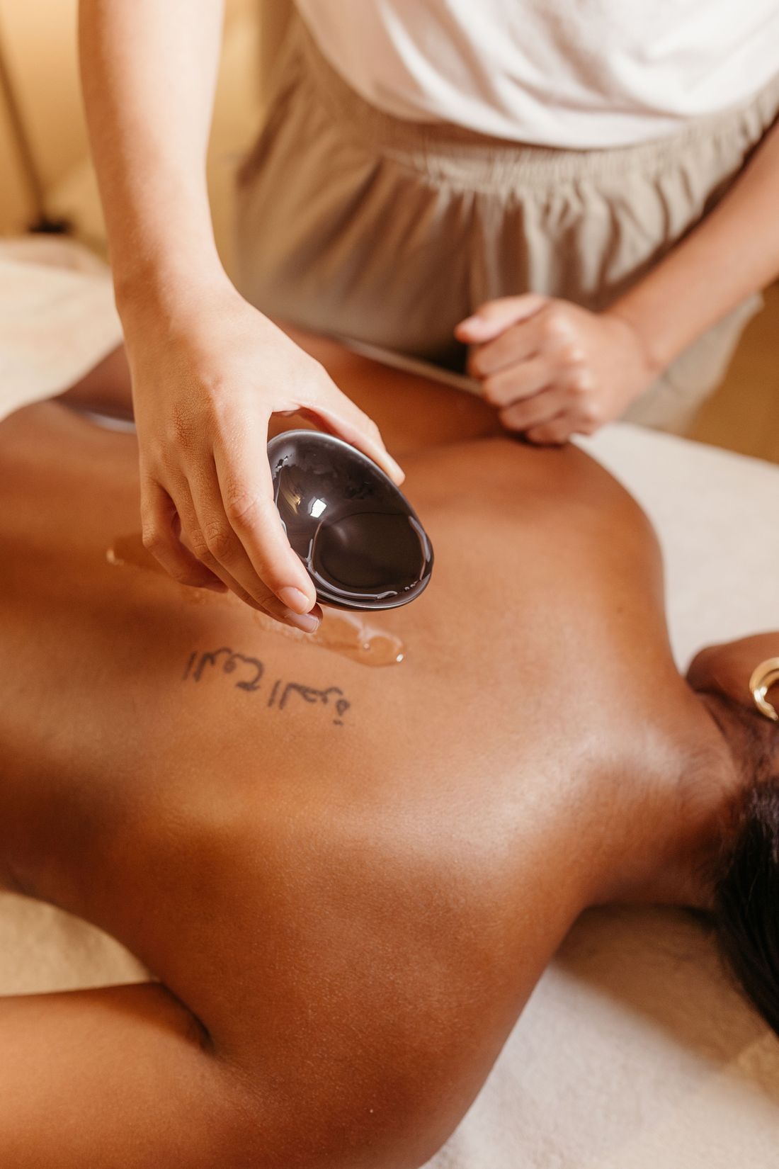 Huile tiède versée sur le dos avant un massage californien
